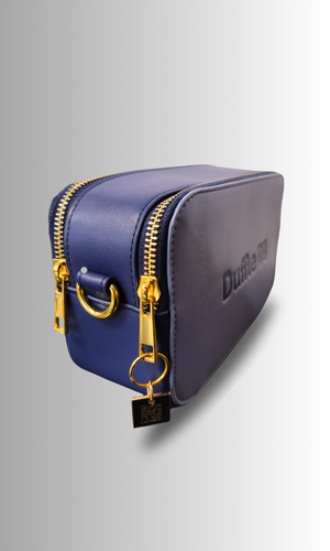 Side view of the Ocean Journey Crossbody Bag displaying the Duffle Bag logo key chain, highlighting the bag's branding and attention to detail.